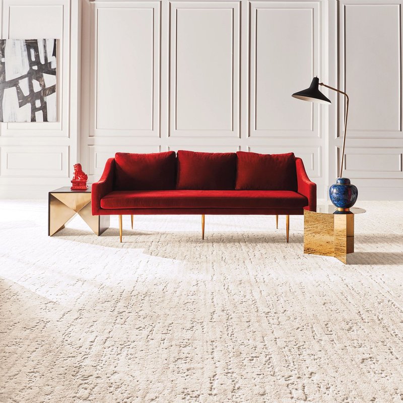 A red couch on a white capet in the middle of the room from Floortech Corporation in Greenwood